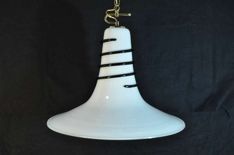 Stunning vintage single light bell shaped Murano art glass pendant light with black swirl design and great modernist form. The glass shade hangs from a brass mount.