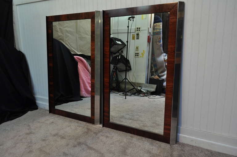 Great pair of vintage mid century modern Brazilian rosewood wall mirrors with parallel angled chrome accents to the frames. The mirrors would look wonderful hanging long or tall ways. Mirrors are unmarked with the design being attributed to Ed