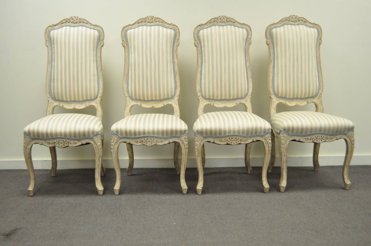 Great set of 4 vintage carved and cream distress painted dining chairs in the Swedish Rococo / French Louis XV Style. Chairs feature shapely cabriole legs, carvings throughout including the crest, lower back rest, and rails, and classy elegant form.