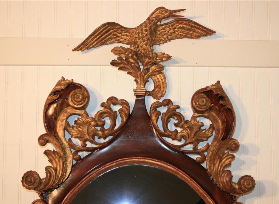 Wonderful Large Antique Mahogany and Gilt Wood American Federal Style Oval Mirror with Fine Carved Gold Gilt Mallard /  Duck Crown. Item features very fine and detailed wood carvings, gold accents surrounding the frame, and classic federal style.