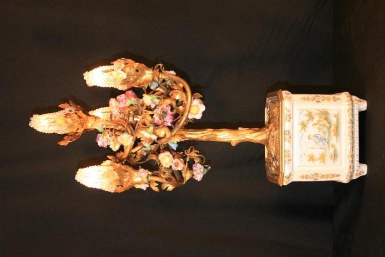 Beautiful French Four Light Gilt Bronze Figural table lamp having a hand painted porcelain flower pot base and hand painted porcelain floral accent. Item feautures very fine and detailed bronze work. Lamp measures 19
