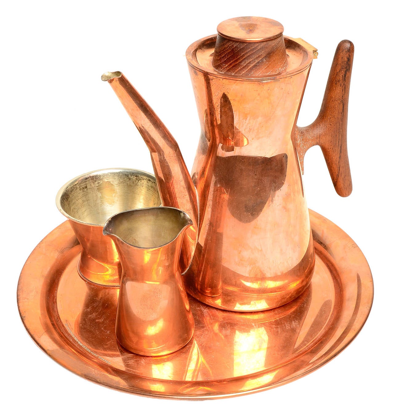 A solid copper coffee set including coffee pot, creamer, sugar pot, and very hard to find solid copper serving tray.
Lined in silver, these sets were produced in very limited numbers . Hand made to order, these are very rare .
This is the large