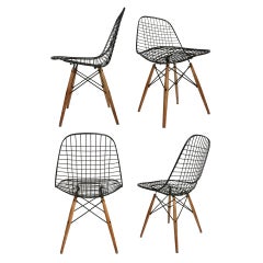 Early set of four Birch dowel base Eames wire chairs