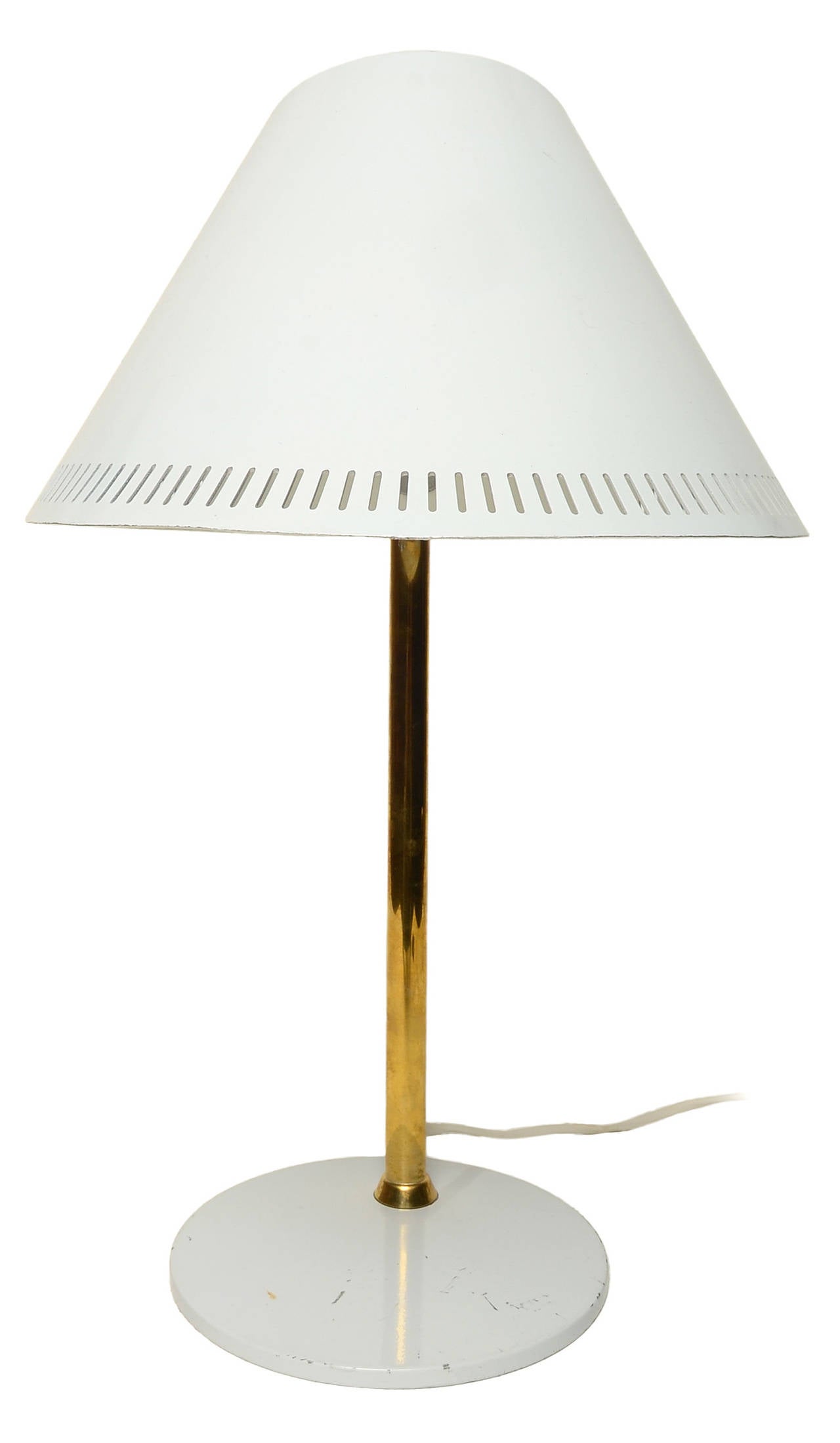 An adjustable table lamp by Paavo Tynell for Idman, circa1950

This example retains it's original enameled white shade with a solid brass upright and adjustable thumbscrew.

Stamped to base.