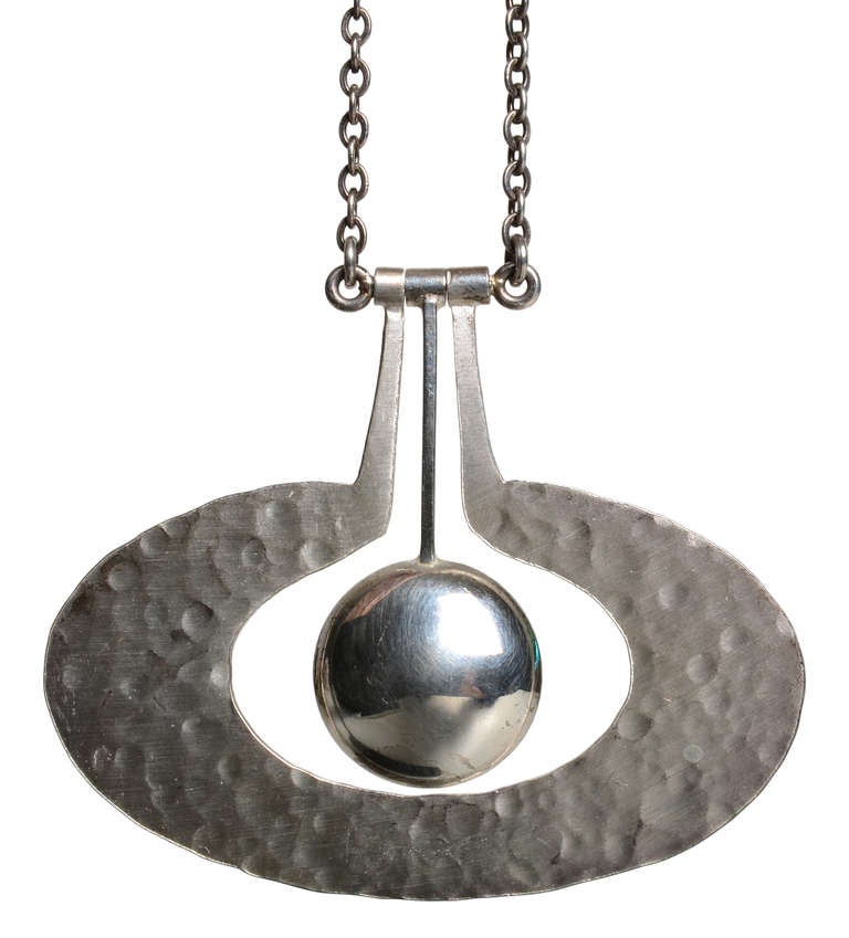 A beautiful kinetic silver pendant by Tapio Wirkkala.
A central silver flattened orb surrounded by a hand hammered apple form.
An iconic piece of jewelry by the Finnish master craftsman.
Stamped with manufacture marks, Tapio cypher, and silver