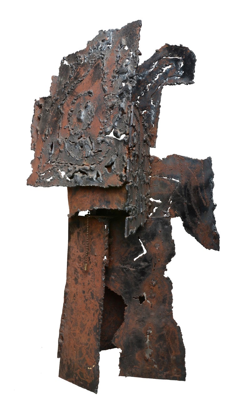 Eine sehr schöne stark gearbeitete Metalllampe.
Dickes durchstochenes und geschnittenes Rohmetall mit aufgesetzten Schweißnähten und Falten.
Ein Meisterwerk des Brutalismus.
Brauchbare Skulptur.

