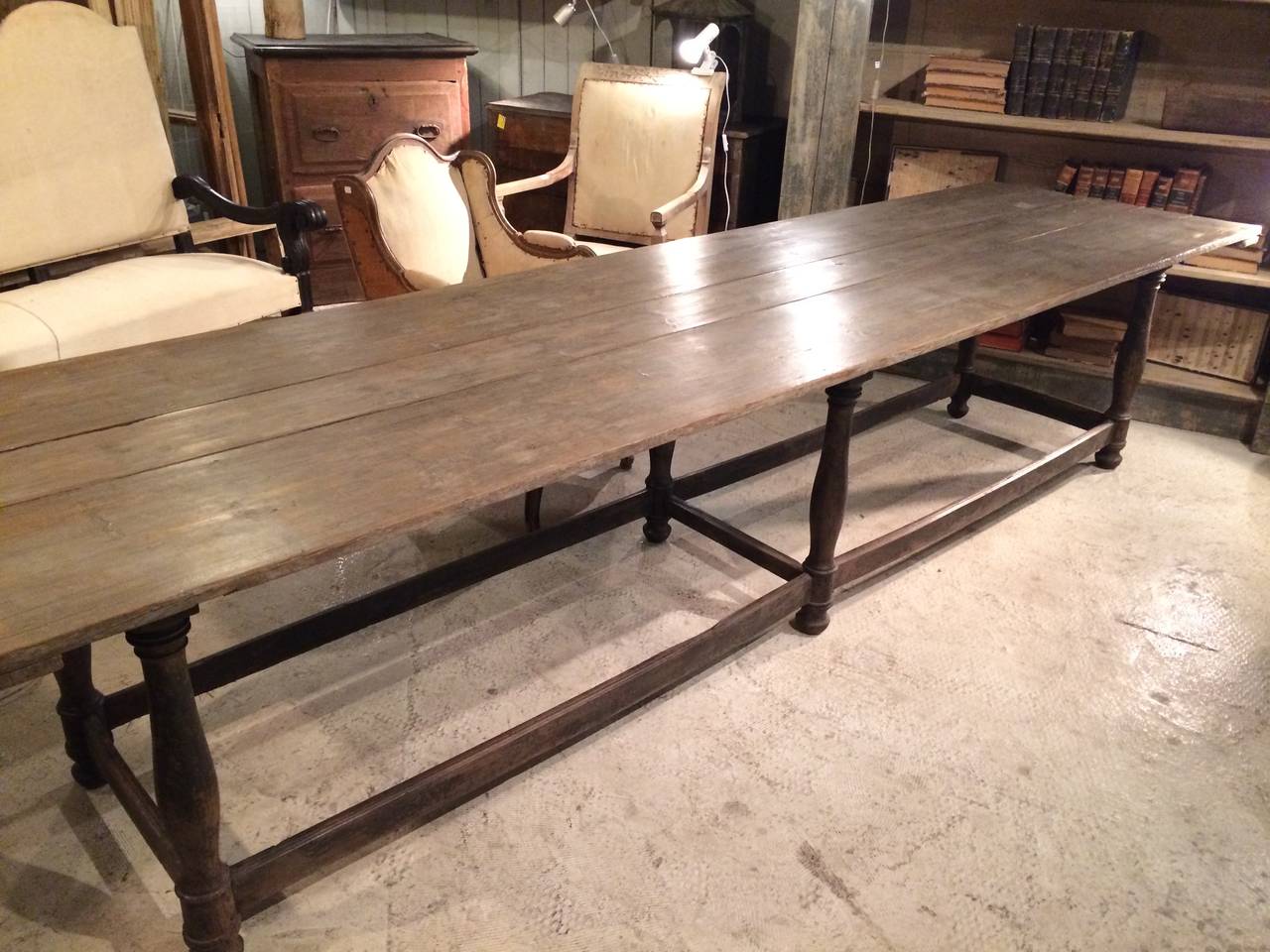 Early 19th century 11ft French oak refectory table with deep gray patina, carved legs and stretchers.