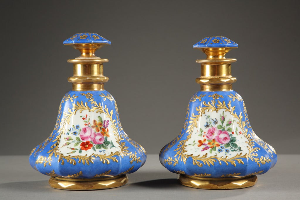 Pair of blue porcelain bottles embellished with scrollwork painted gold. They are decorated with multicolored flowers on one side and on the other a character in a landscape background . They are signed DARTE, Palais Royal, No. 21, which dates them