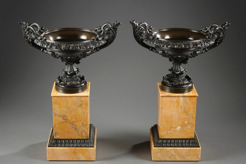 Pair of fine patinated bronze two-handled scrolled Louis-Philippe cassolettes resting on a quadrangular Sienna marble base. The vase à l'antique is decorated with acanthuses, palmettes and foliage.
