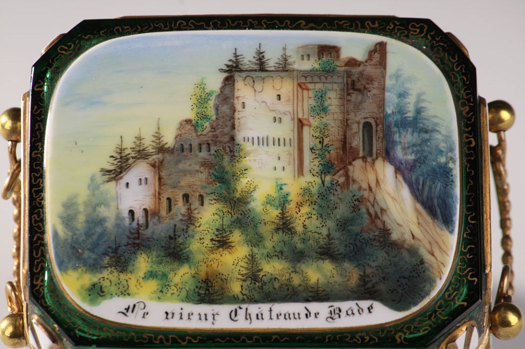 A small square casket in green overlay glass and gilt brass mounts decorated with picturesque views of the German city Baden-Baden and its monuments: on the lid, a view of the Ancient Castle and on the other faces four views of the Conversation