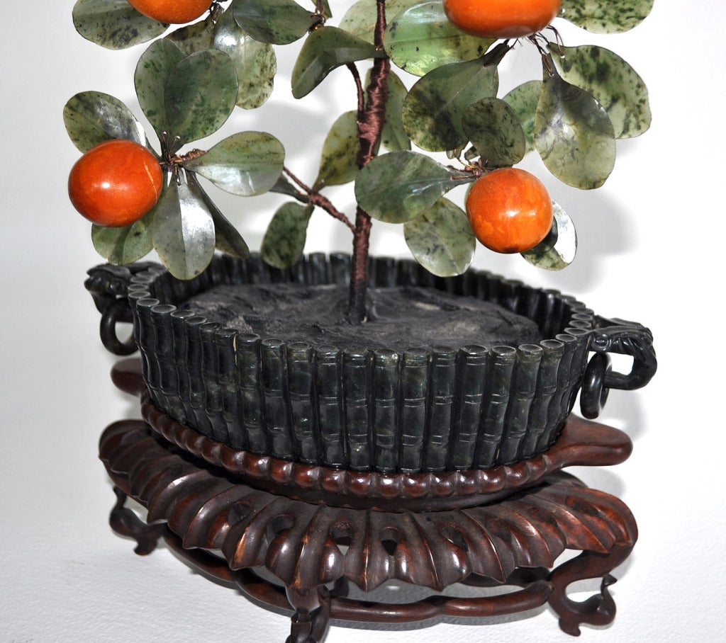 This is a stunning pair of extremely well executed and conditioned jade trees in intricate spinach jade bowls with jade leaves and large egg gold amber fruit with hardstone flowers. 19th Century. A pair.