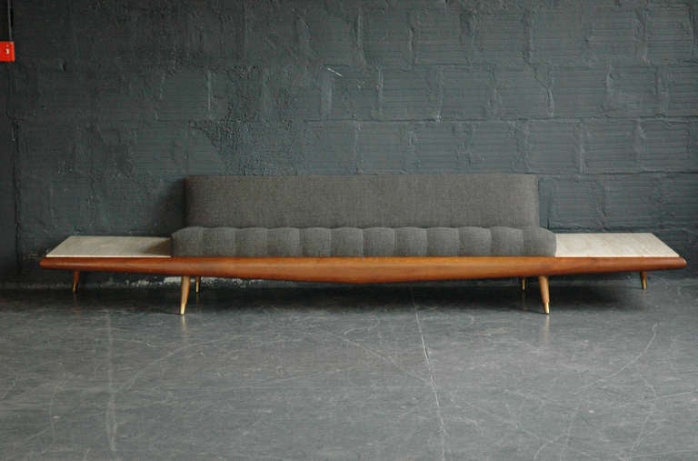An incredible and rare daybed-style sofa with integrated marble-top side tables. Solid walnut fascia and side trim with steel frame. Matching legs with brass feet. Reupholstered in new fabric.

This piece is currently being repaired – inquire