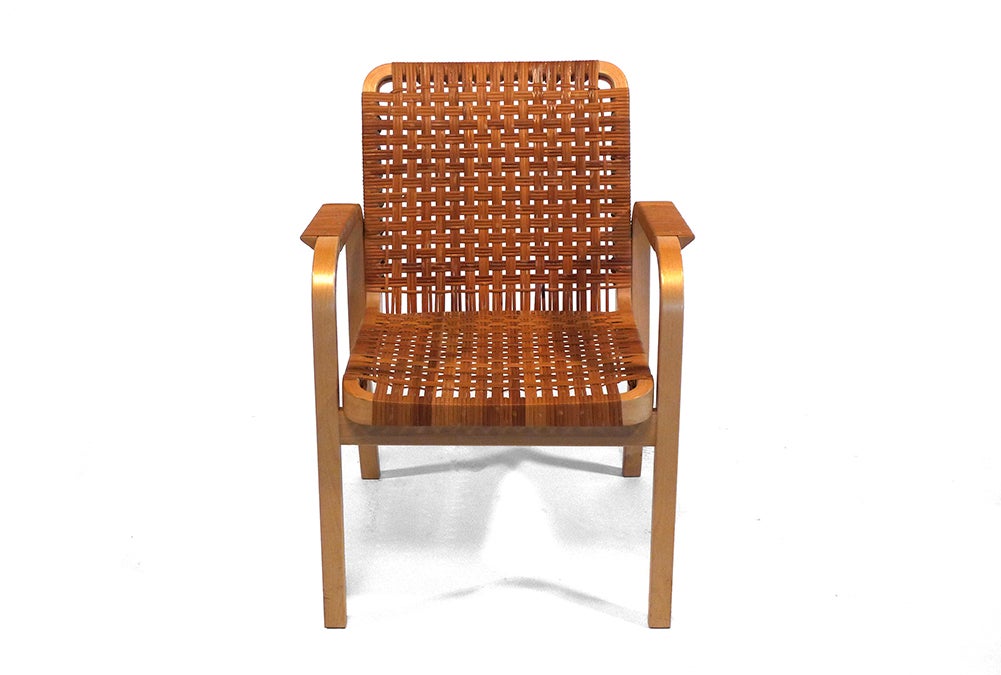 A classic early design by celebrated Finnish architect and designer Alvar Aalto. This example features rare rattan cording, which has darkened and taken on a rich patina with age.
Aalto was a proponent of a “humanist” Modernism, and his