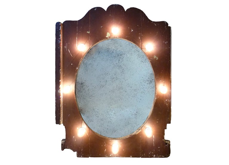 large antique panel originally part of a circus display or carousel, with antiqued mirror and eight light bulbs.