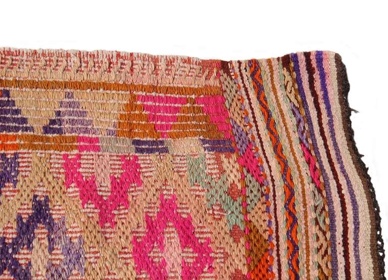 vintage anatolian turkish kilim with horse hair fringe. this classic antalya kilim includes colors of bright pink, orange, and violet.