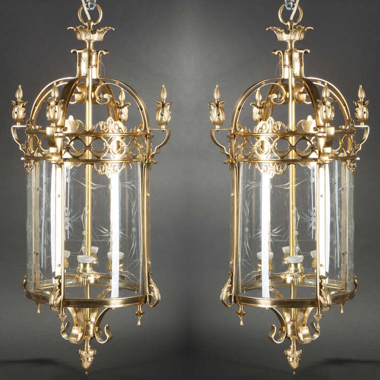 Pair of gilt bronze and glass lanterns, decorated with acanthus leaves.
The four glass faces curbed and wheel-engraved on the inside with radiating plant motifs. Circular gallery decorated with a frieze of circular motifs.
Fitted for