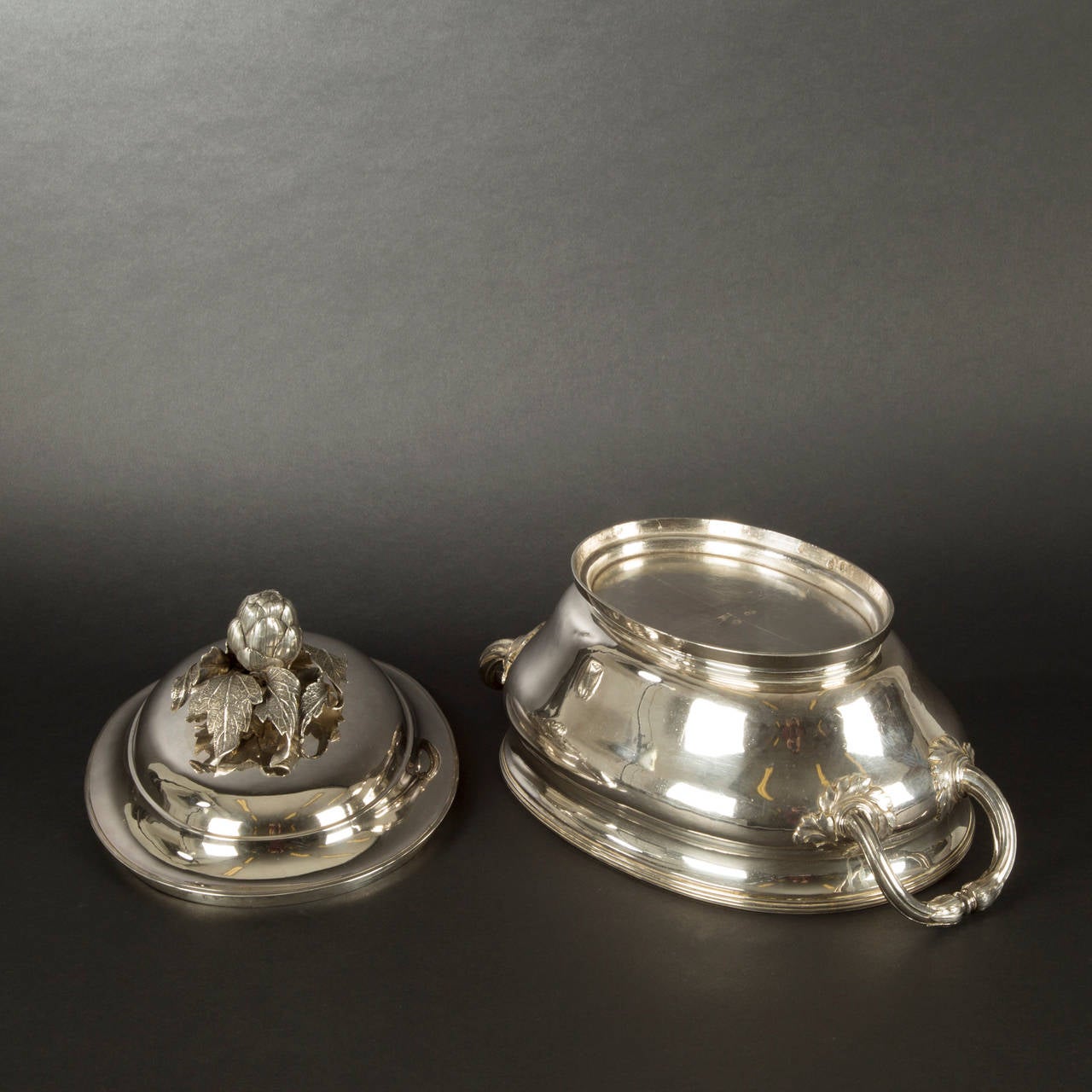 Plain silver oval covered soup tureen, side handles with foliage attachments, ogee domed cover with an artichoke finial.
Silversmith : Jean Charles Moree

Paris, 1781

Length including handles : 37cm (14-3/5in).

Weight : 2400gr (77oz 4dwt)