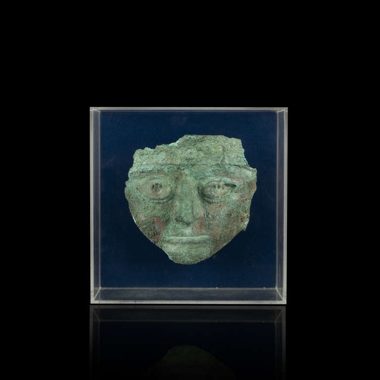Mask. Copper with thick crusty green patina, eyes were modeled separately and affixed by two metal prongs.
Peru, North Coast, Chicama Valley, Vicús, 400-200 A.D.
Height: 19 cm (7-1/2 in.) - Width: 19 cm (7-1/2 in.).