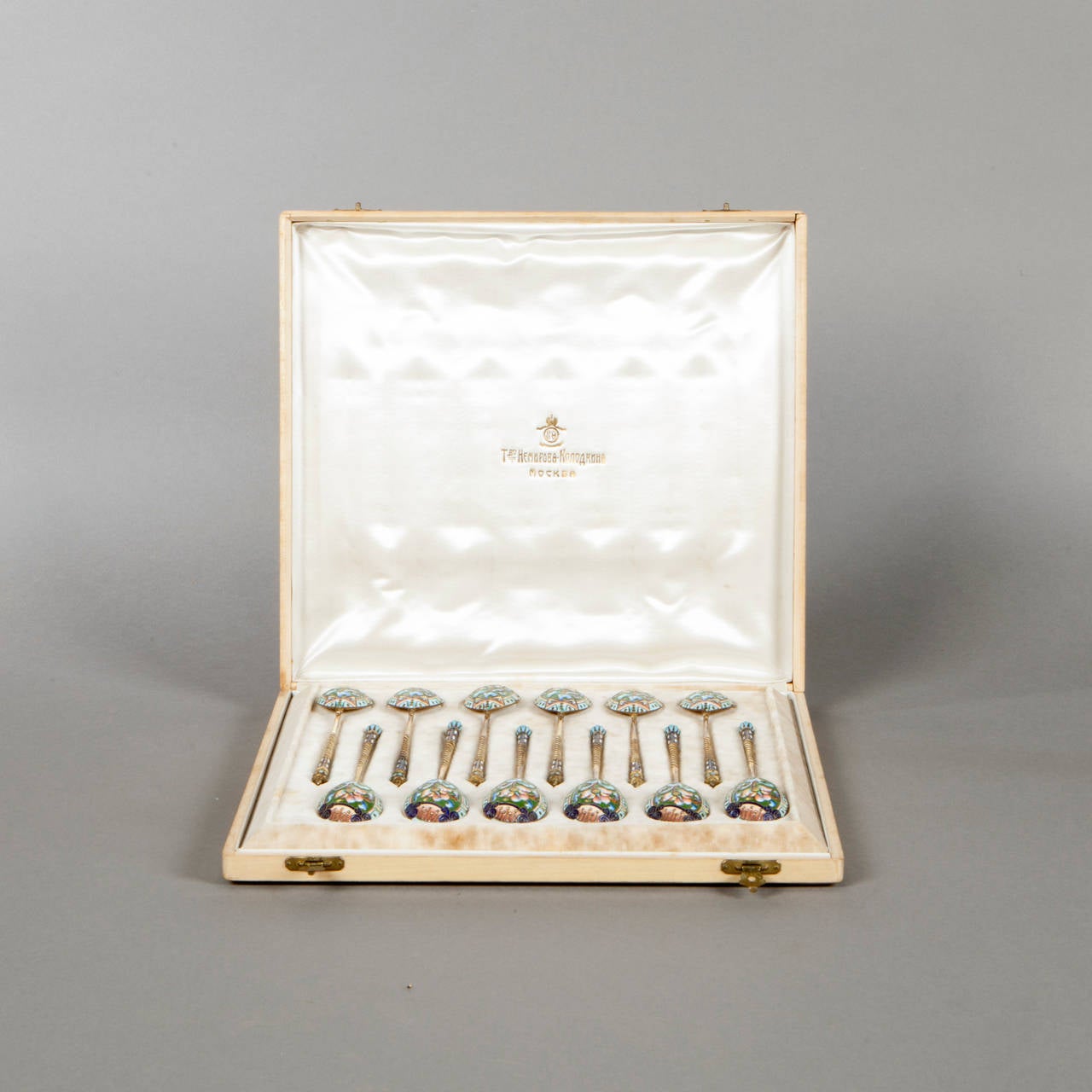 Twelve silver-gilt tea spoons with twisted handles. 

Polychrome cloisonné enamel decoration of green flowers within surround of geometrical motifs. Moscow, 1908-1917. 

Length : 14cm (5-1/2in). 
Total gross weight : 283g (9oz 2dwt).