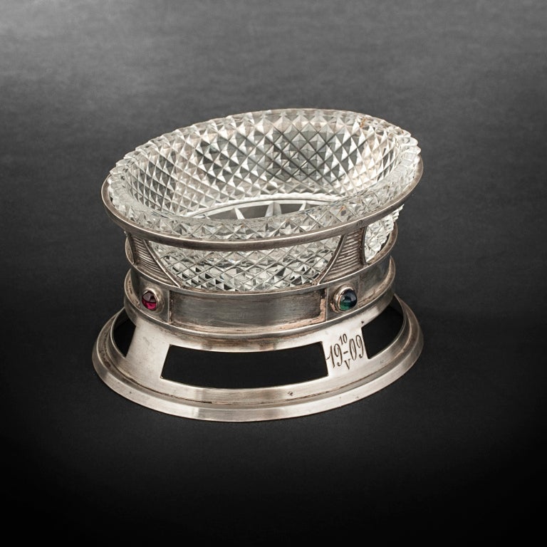Oval pierced and engraved salt cellar. Sides set with four sapphires and cabochon rubies.
More details available on : http://en.expertissim.com/silver/salt-cellar-by-karl-faberge-o12122520.html?utm_source=1stdibs