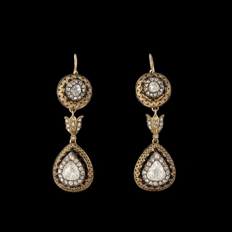 Pair of gold and diamonds pendant earrings

Pair of gold 18K (750 millièmes) pendant earrings. Upper part ornated with one crowned rose-cut diamond within surrounding of rose-cut diamonds and black-enameled gold balls. Pendant with one important
