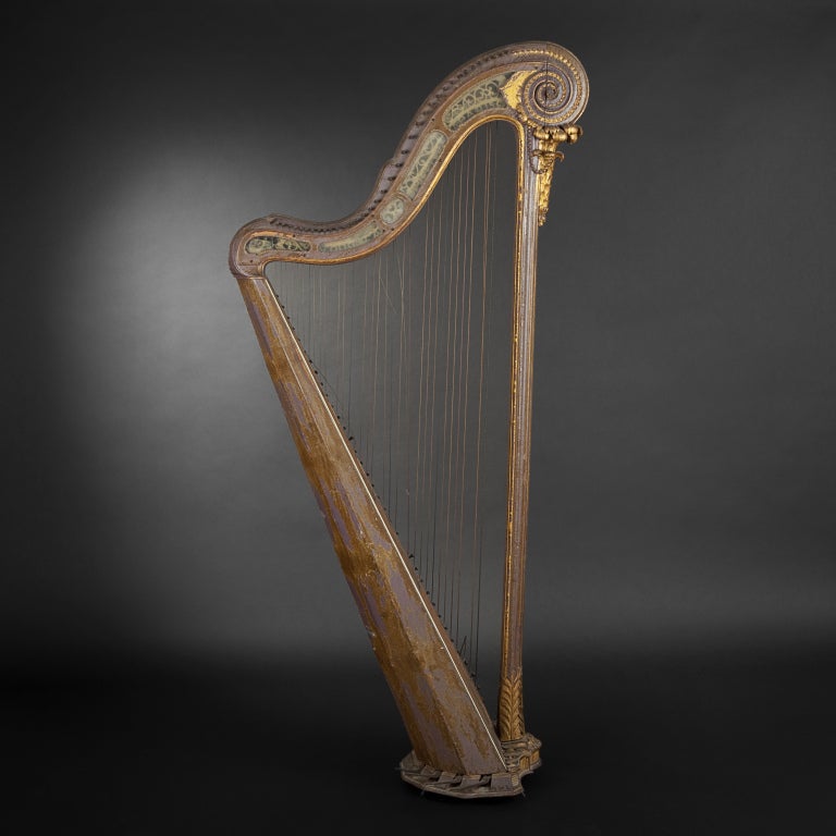 Moulded, carved, re-gilt and re-lacquered wood harp.
Column supporting crook-shaped crown carved with palm leaf and beads. Soundbaord decorated with Chinese motifs and bone and ebony threading. Soundbox with seven canted sides. Pierced neck