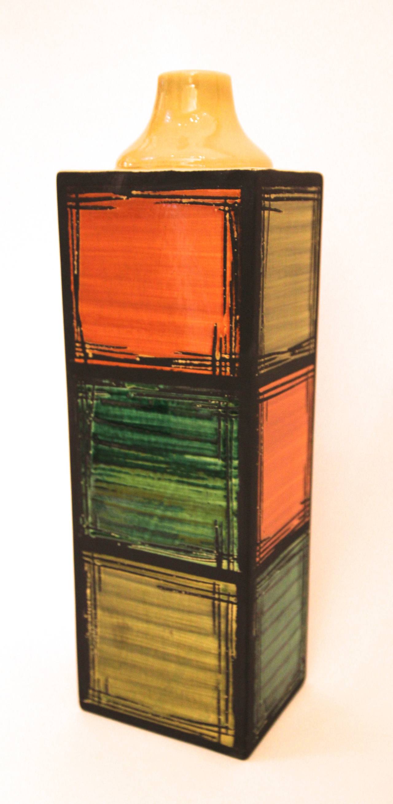 Cau.G Bitossi and Figli, Bottle,
Glazed ceramic, 
Decoration of three orange, green and yellow squares,
Signed, located and numbered 108/149 under the base, 
Italy, circa 1970.

Measures: Height 45 cm, Length 14 cm, Depth 11 cm.

The identity of