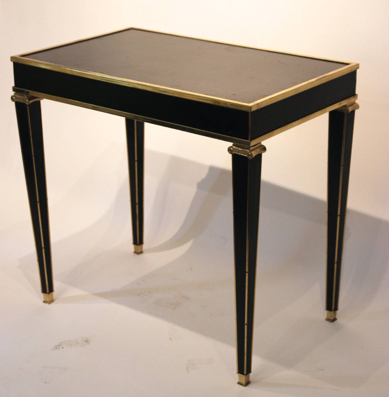 Centerpiece by Marc Duplantier,
wood core wrapped in black leather,
hooves capitals gilded bronze and varnishes,
threads and golden brass corners and varnishes,
France, circa 1940.
Vintage condition.
Measures: Height 76 cm, length 81 cm, width