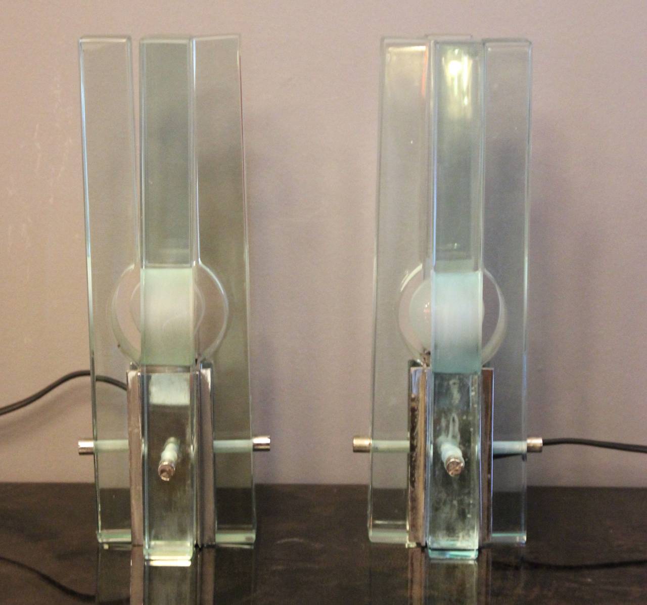 Fontana Arte,
pair of table lamps,
chromed steel and glass,
circa 1970, Italy.
Measure: Height: 30 cm, width 11 cm, depth: 11 cm.