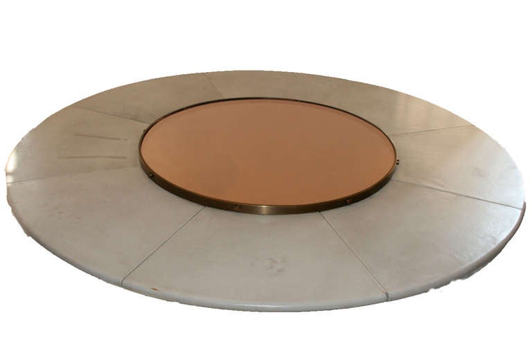 Large bronze and metal table by Marzio Cecchi,
painted metal foot and bronze,
white leather top and turning bronze mirror top shelf, unique piece,
 circa 1970, Italy.
Height: 80 cm, diameter: 198 cm.
