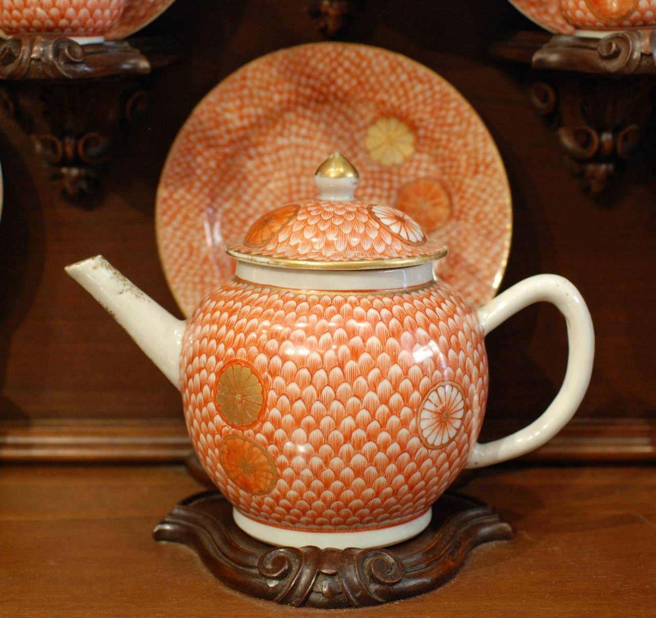 Tea set with 12 cups and saucers, a teapot, a sugar bowl and a small pot, Japanese inspired decorations made in China for the European market in the 18th century. The display cabinet, circa 1900.