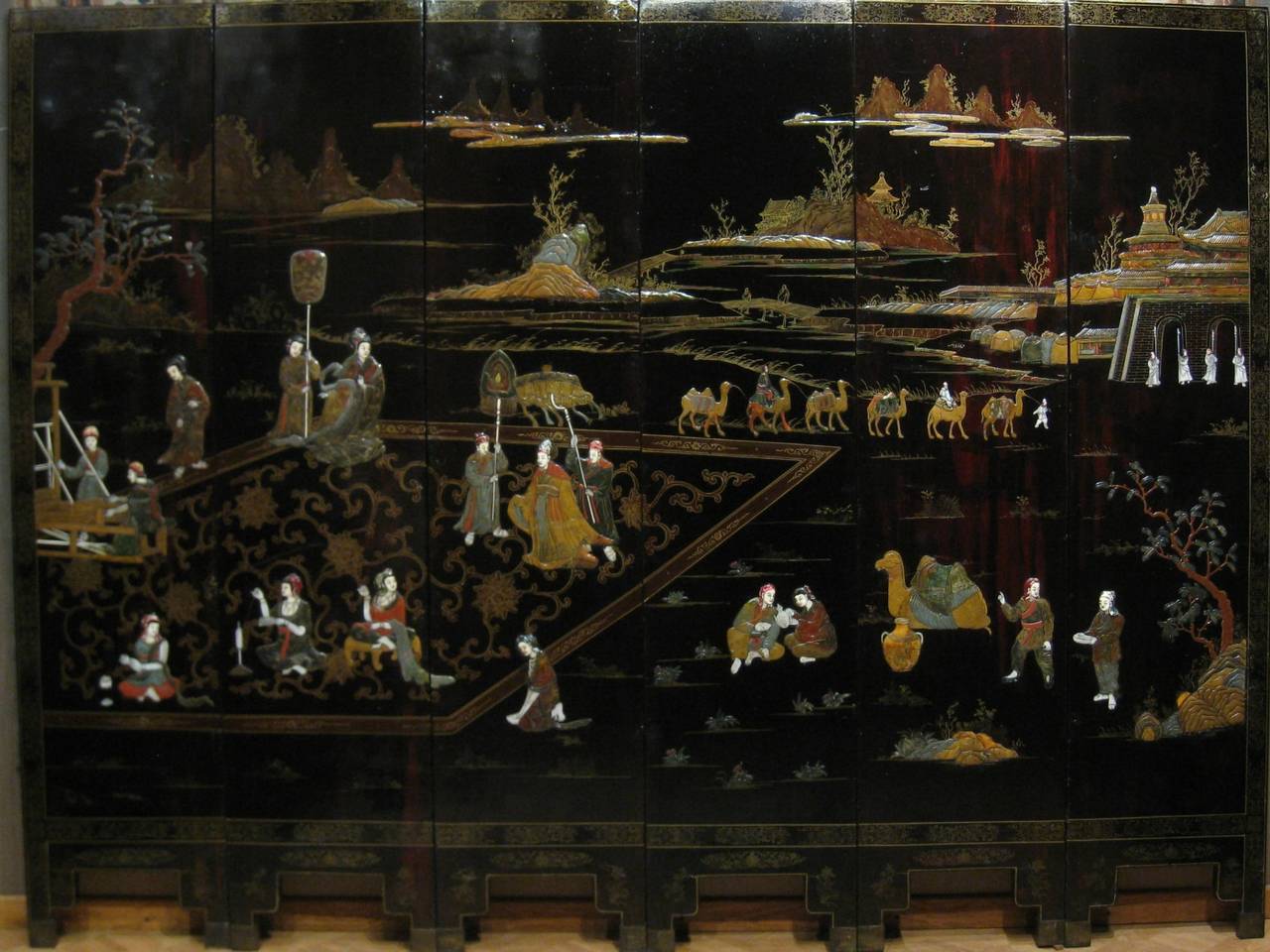 Screen Chinese lacquer 19th century, character sets in a castle landscape, ivory, mother-of-pearl, hard stones and soap stones. The black lacquered back and gold decorations of fantastic birds.