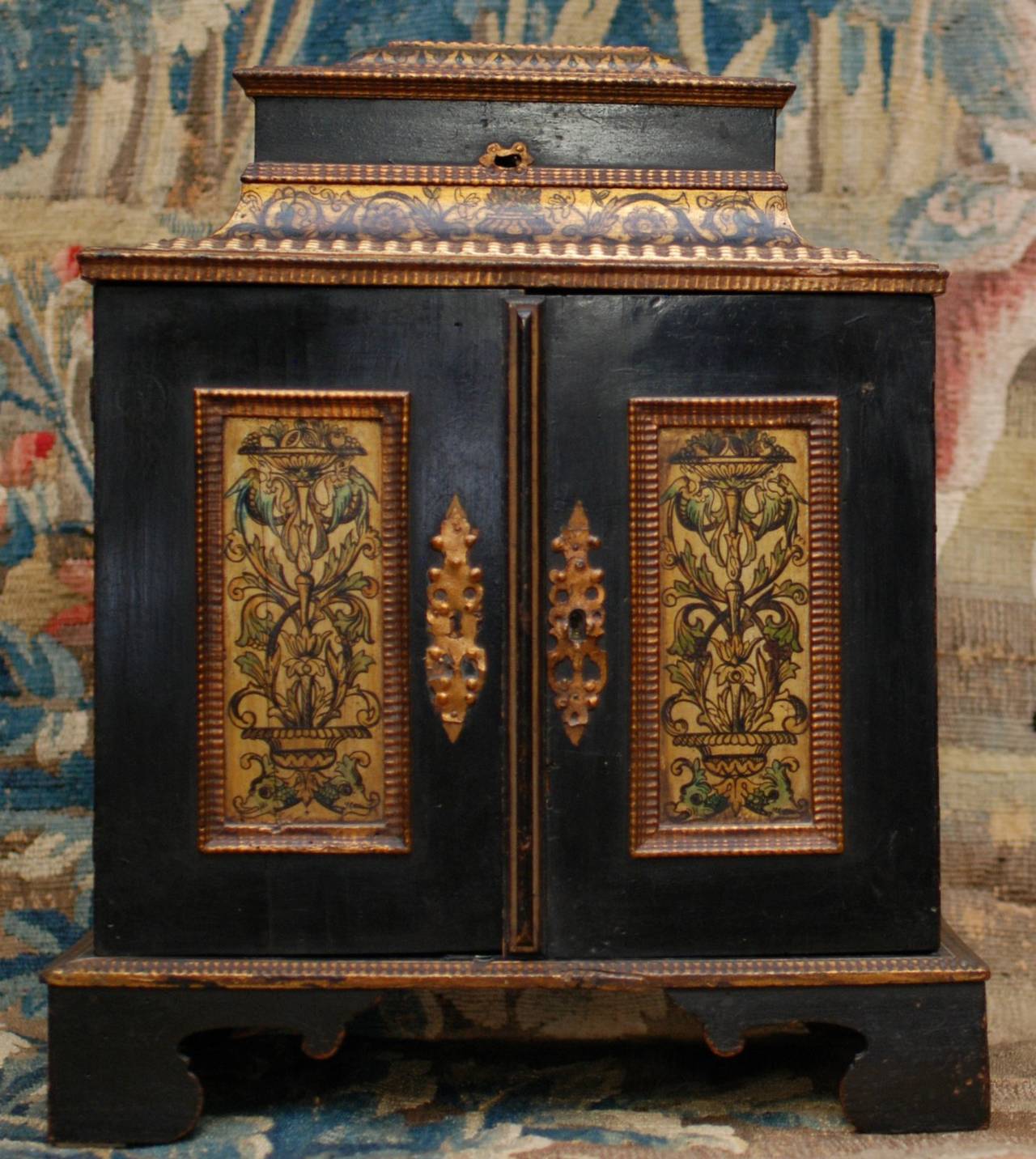 Opening two doors on an interior containing eight various drawers, lacquer painted a venus with birds, scrolls and foliage.