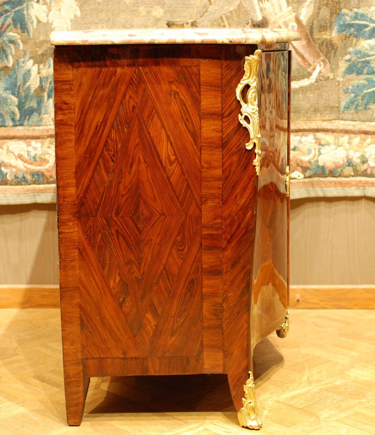 Surmounted by a brèche d'Alep serpentine marble-top, opening by two doors
with veneered Kingwood, the projecting angles with pierced trailing ornament,
on short legs with sabots. 
Stamped by Jacques Dubois Maitre en 1742.