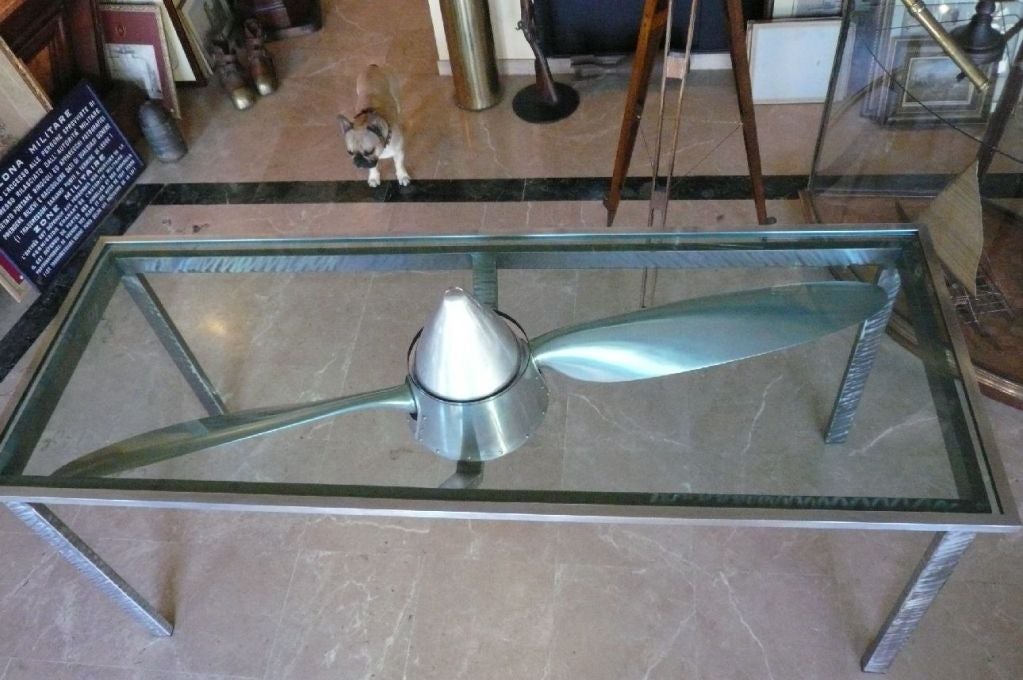 This table was made some years ago for a flying club of southern France.
Built with quality materials to showcase an airplane propeller with variable pitch,
it was designed to allow the blades to be always moving.
The cone through the glass plate