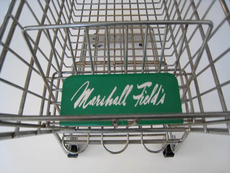 A whimsical miniature steel shopping cart probably used for display at the now defunct Chicago Department Store, Marshall Fields. Marshall Field & Company was a Chicago institution for more than 100 years. It's purchase by Macy's in 2005 caused a