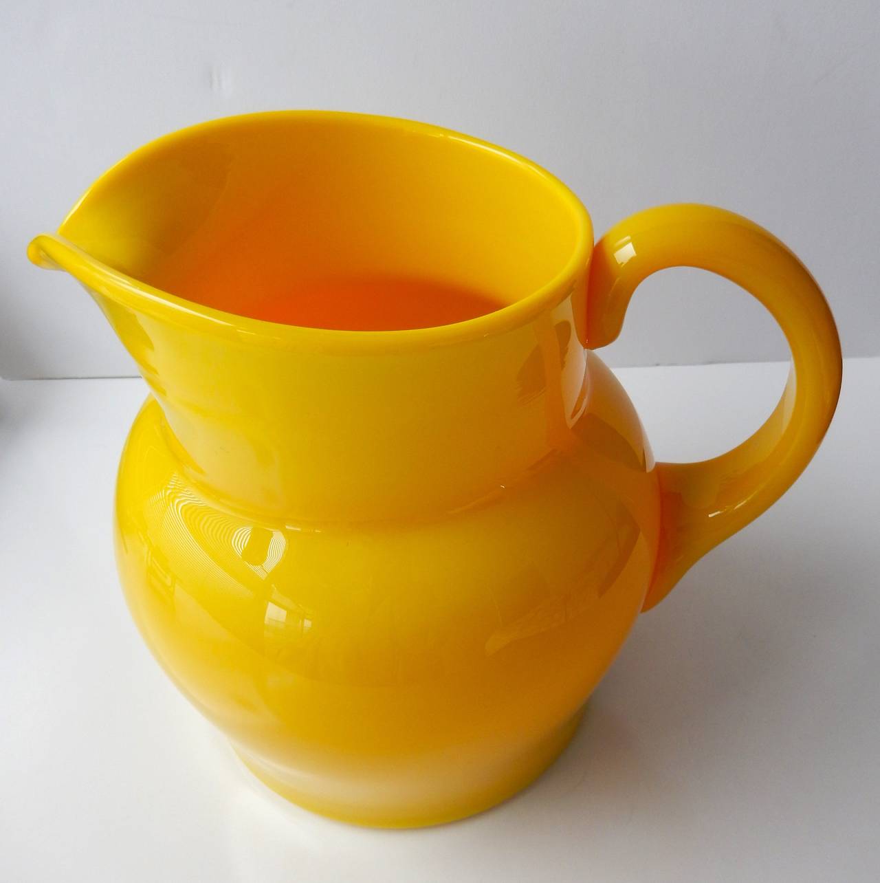 A handblown, saffron yellow glass pitcher by the Swedish artist
Erik Hoglund (1932-1998). His work is included in many museums throughout the world including: Nationalmuseum, Stockholm; Corning Glass Museum, New York; Victoria and Albert Museum,