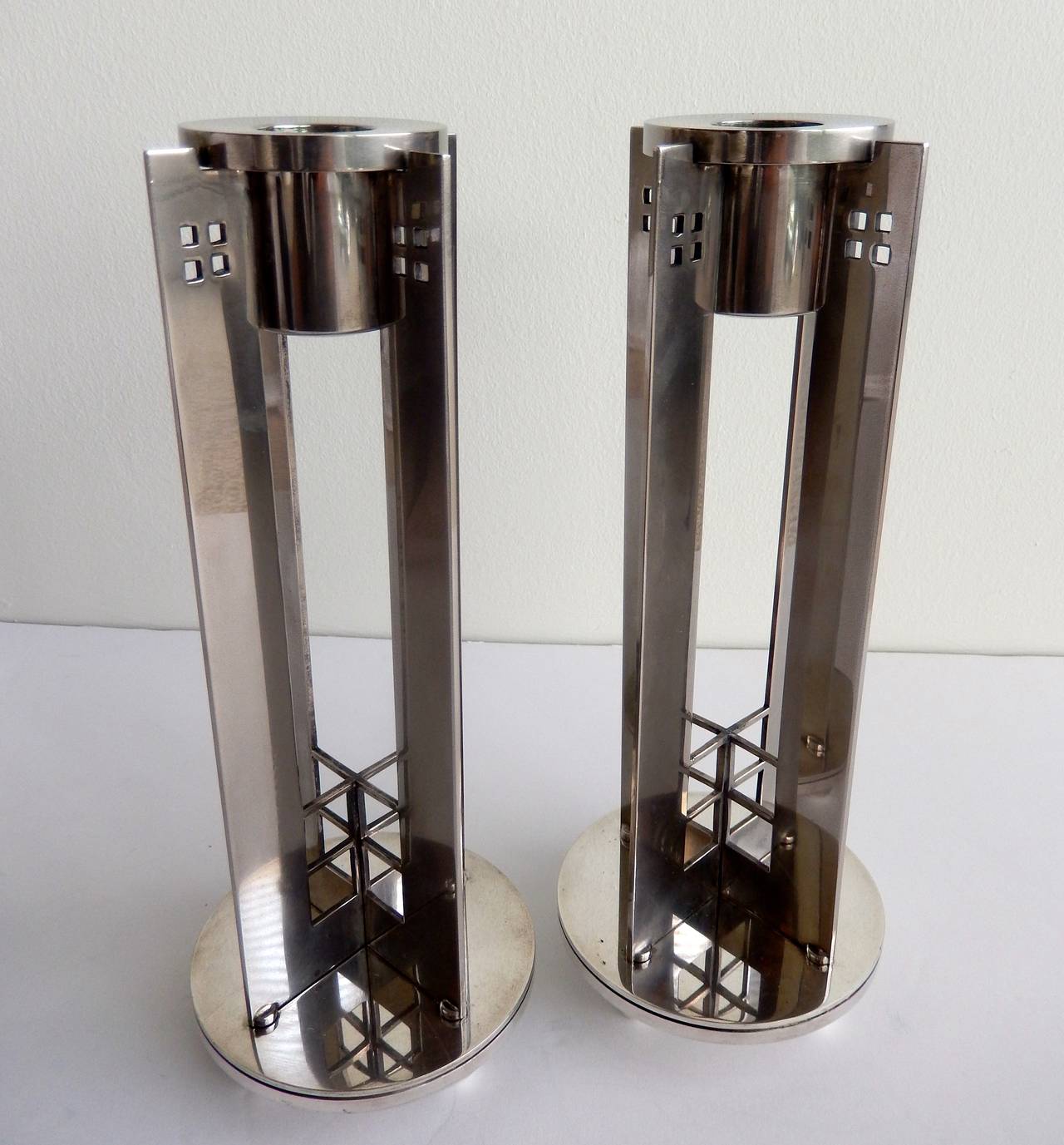 A pair of silver plated, vintage candlesticks with ball feet designed by the modernist American architect Richard Meier for Swid Powell. Their modern, geometric design with buttressed panels and square cut-out reflects Meier's interest in classical