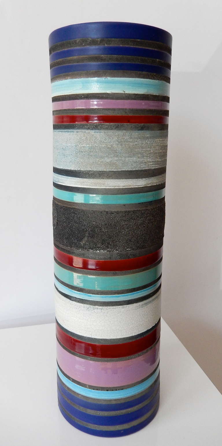 A tall, striking cylinder vase by Memphis founder Ettore Sottsass (1917-2007) for Bitossi Ceramics.  This design is from the Rochetto series, 1955-59.  The vase is decorated with bands of richly- colored matt and gloss glazes combined with opaque