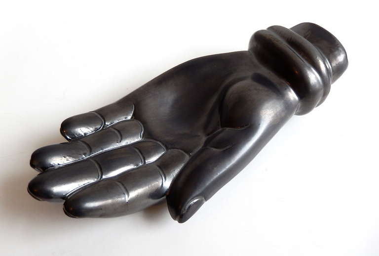 A ceramic hand sculpture with a rich gunmetal glaze by French actor and modernist potter Jean Marais.  This work reflects the surrealist spirit of Jean Cocteau and his circle.