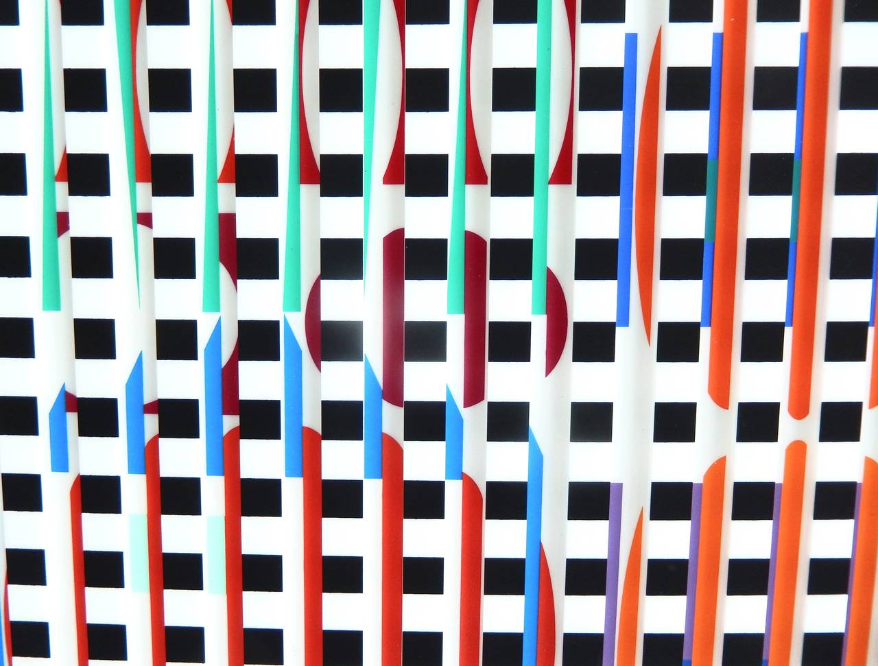 An op art, kinetic wall construction by Israeli artist Yaacov Agam (b. 1928).
A moveable grid of black and white squares reveals an image underneath, and allows the viewer to slide it across the work. The movement of the top screen displays an