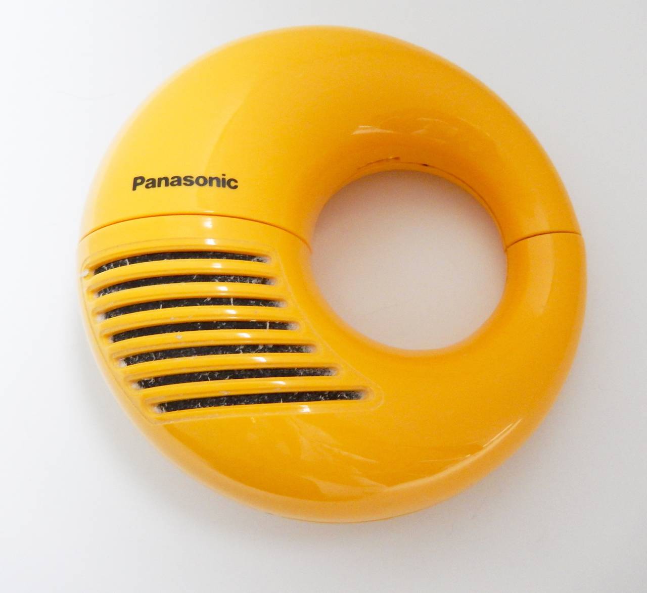 A bright yellow Toot-A-Loop AM radio by Panasonic in very good condition. 
This battery-powered wrist radio is doughnut-shaped and when twisted open, reveals the dial inside. Great, modern 1960s design. In good working condition.

An example of