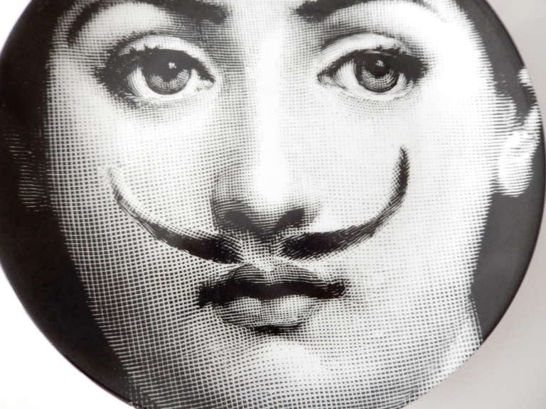 Early plate by Fornasetti with a Daliesque moustached image of a woman's face.  A favorite theme, Fornasetti created more than 500 plates depicting variations on this female image that was taken from a 19th century illustrated