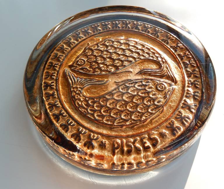 An Italian molded gilt glass paperweight with a stylized, intricate Pisces fish design. Original labels.