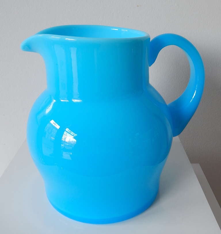 A rare, blue opaque glass pitcher by the Swedish artist Erik Hoglund (1932-1998).  A similar piece is on view in the Miller House, Indianapolis Museum of Art, in Columbus, Indiana.  (See Image 5)

Diameter of base:  4.88 in