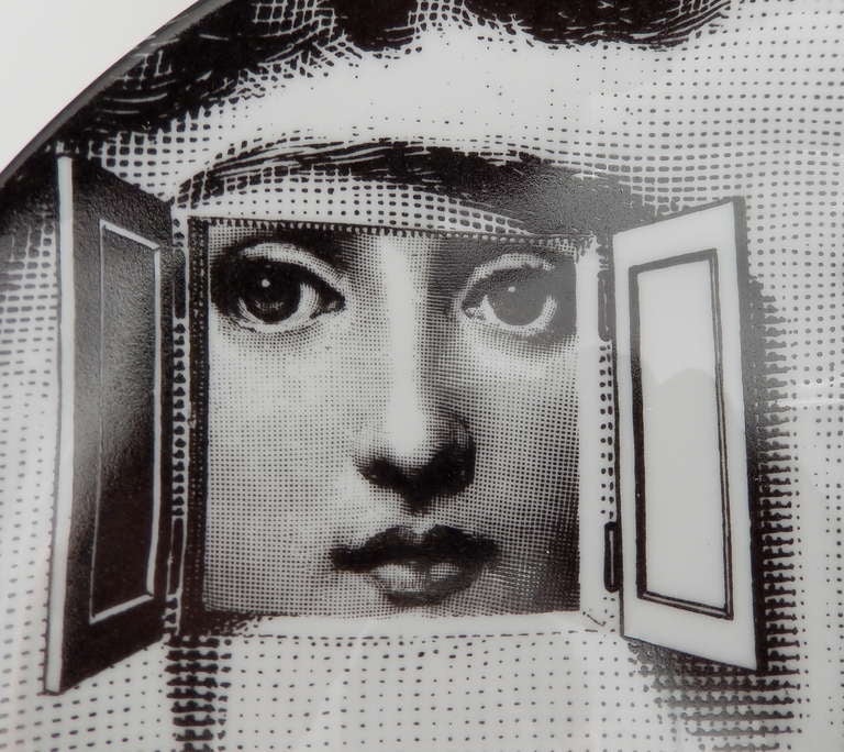 An early production plate by Fornasetti with a particularly striking 
surrealist image of a woman's face.  Fornasetti took the image from a 19th century French magazine and created many variations of it, mostly on dinner plates.  A similar plate is
