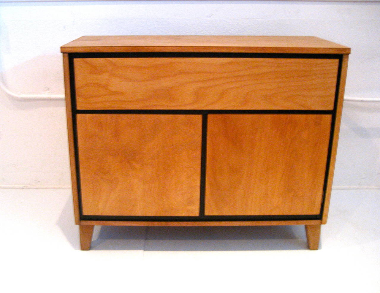 Small kitchen cabinet in solid maple wood designed by Russel Wright for Conant Ball Furniture, totally restored with a black trim edge, circa 1950s part of the American modern atomic age movement. With a top drawer and double door bottom. High