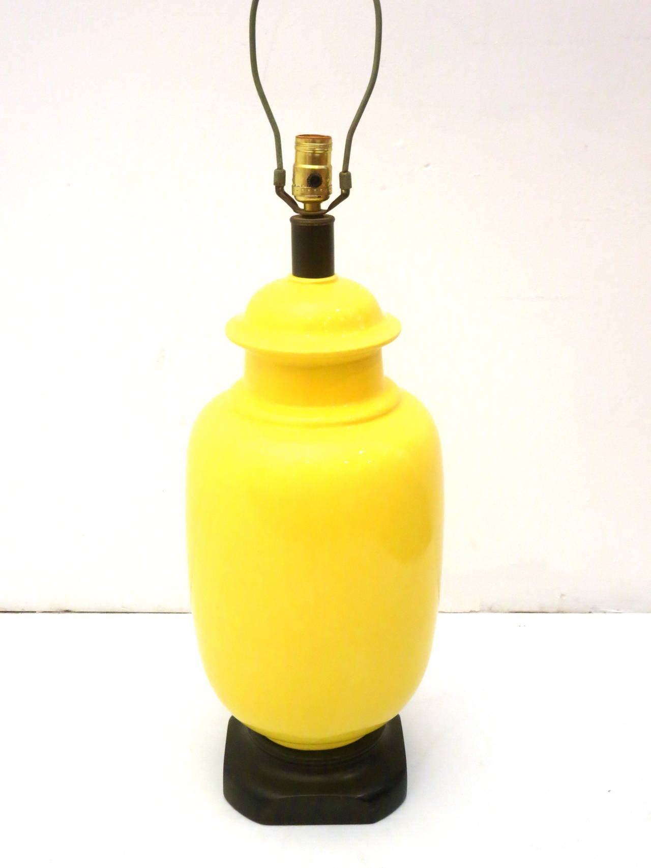 Striking tall yellow ceramic base lamp on a black lacquered wood base, in great condition circa 1970s, the lamp shade its original its got some wear due to age, no chips or cracks. The lamp its 26