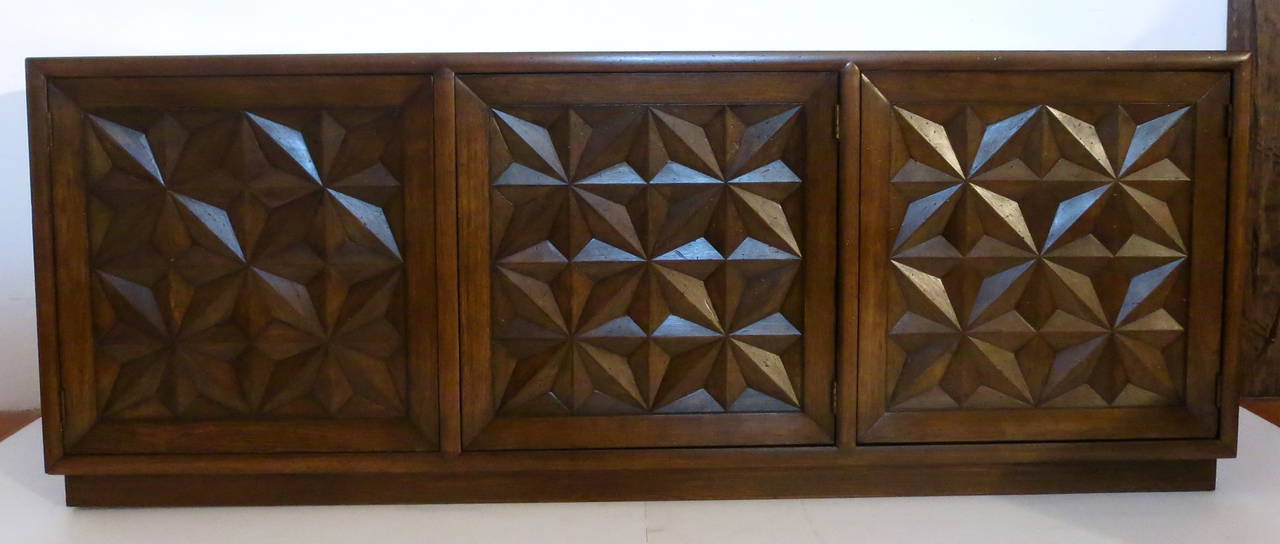 A one of a kind credenza by Henredon, in a light distressed oak finish, and a chocolate stain finish, with three drawers in the middle and two side compartments, with glass shelves, the front doors have star carved design, circa 1960s, incredible