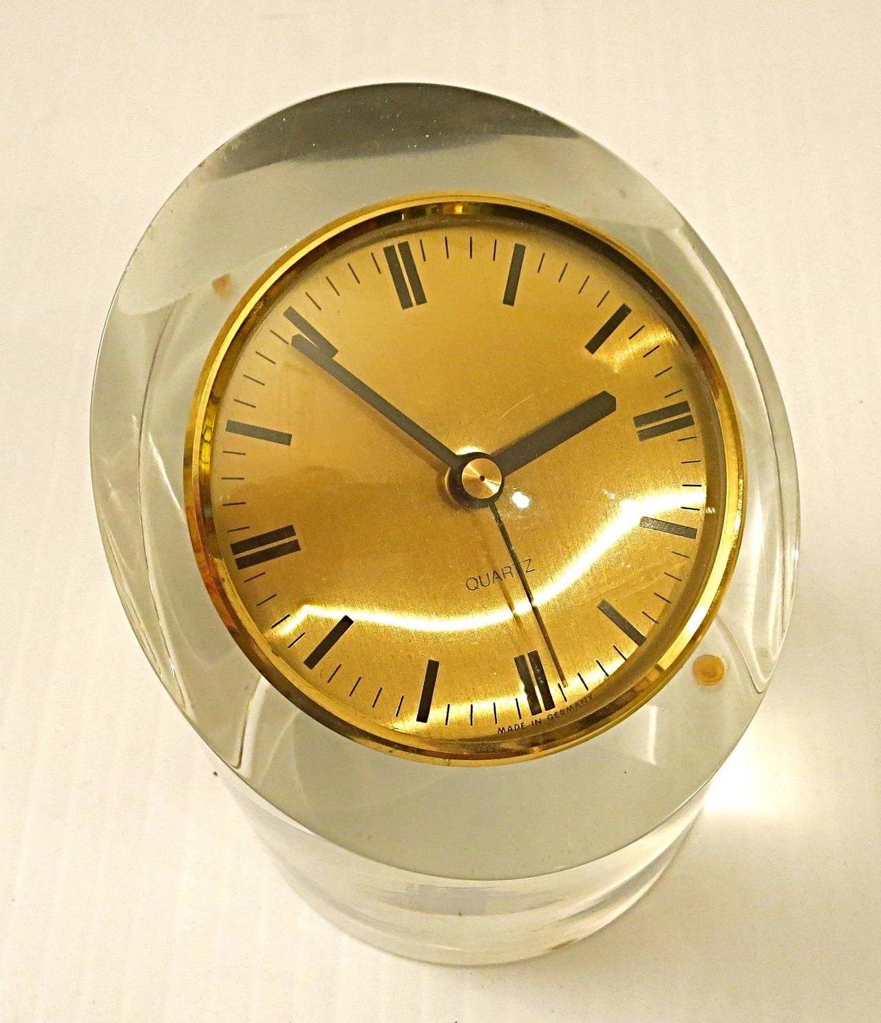 A very unique solid Lucite pipping, cut in an angle with a brass clock with German movement quartz, manufactured by Kienzle and in great condition, the Lucite has been polished and has no cracks or chips. In the style of Karl Springer.